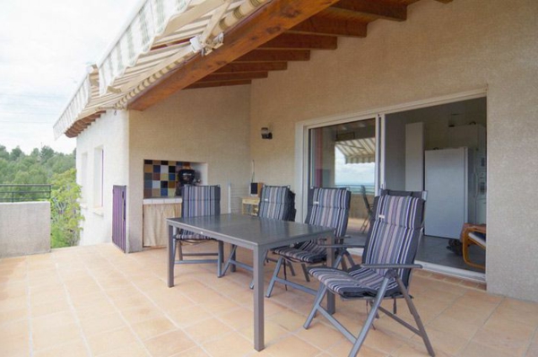 Covered-terrace-gray-furniture-set también con baldosas