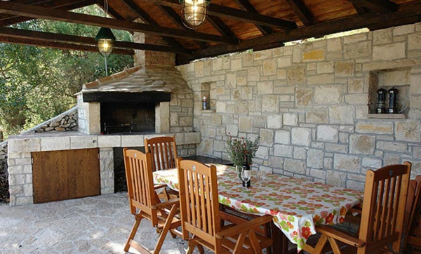 Terraza cubierta-chimenea-piedra-comedor con sillas