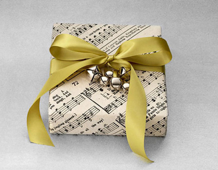 pequeño regalo, envuelto en papel con notas musicales, decoración de campana