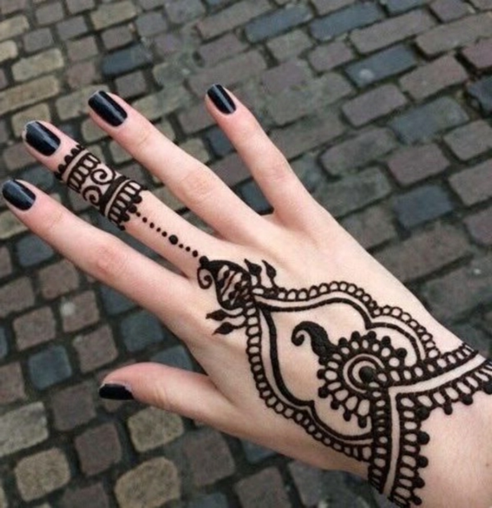 Жена с татуировка на къна на ръката си и на средния пръст в черен, черен лак за нокти