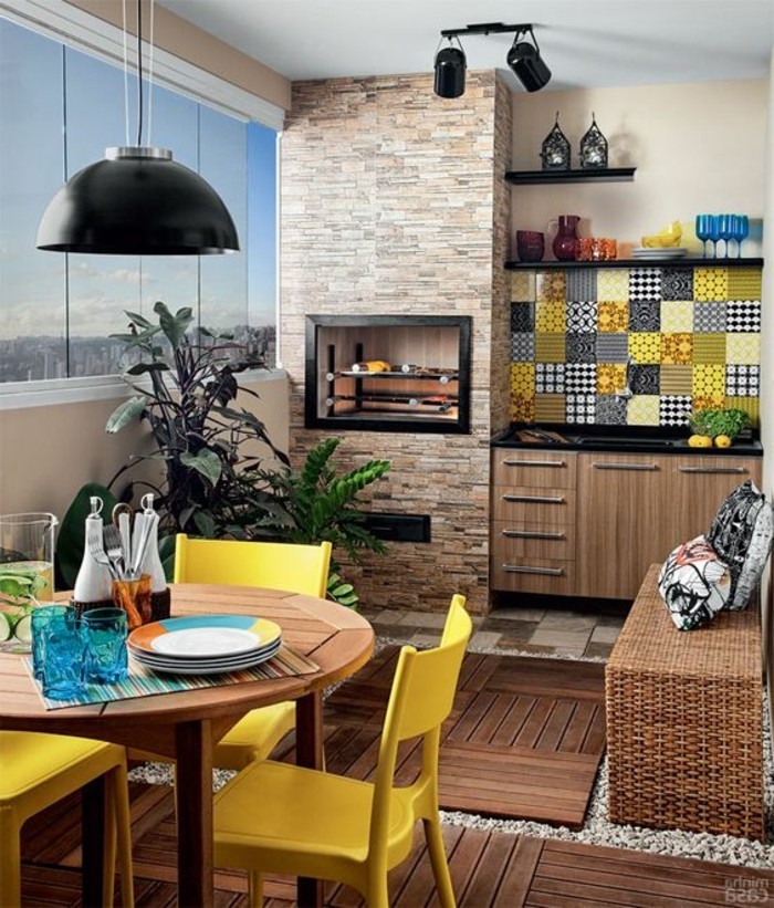 8-kuhinja dekoracija pozadina-cigla-lampa-okrugli-stol-žuto-stolice-kisse-čaše za vino-biljka-prozor
