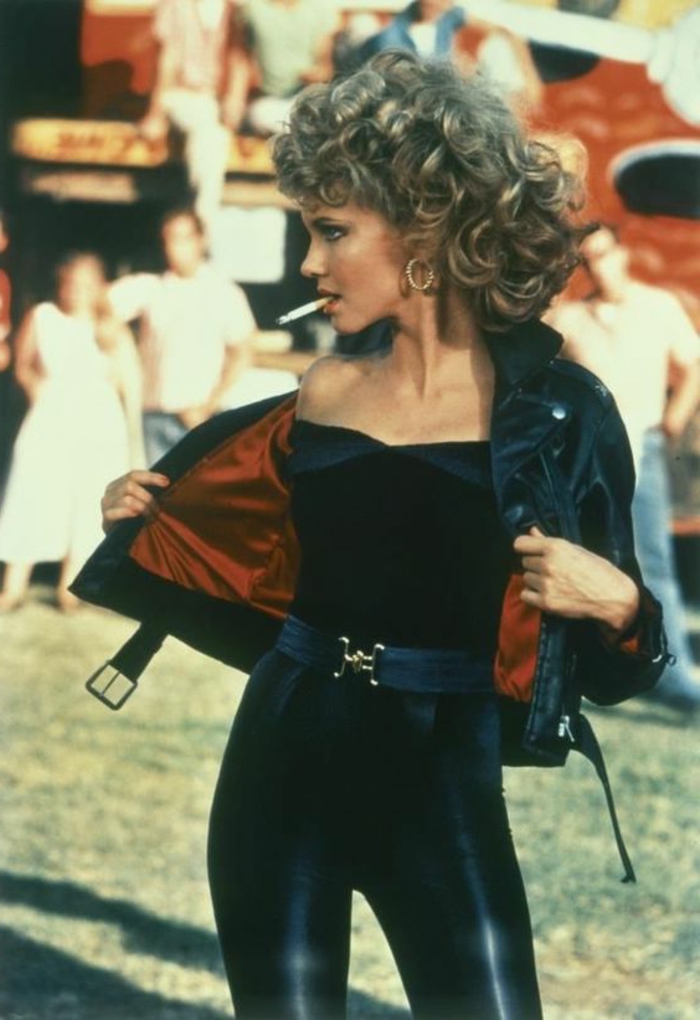 Olivia Newton John odijelo 80-ih s crnim kožnim hlačama, crnom bešavnom bluzom i crnom kožnom jaknom