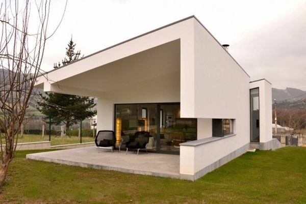 واجهة بيضاء وكرسي بذراعين يطل على الريف لتصميم منزل مذهل