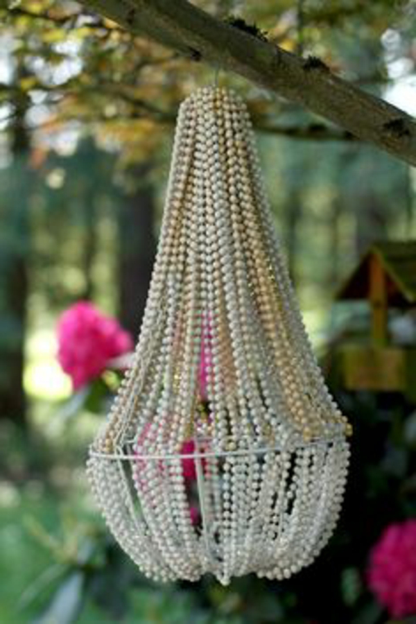 Lámpara de bricolaje hecha de collares de perlas colgando de la rama de un árbol