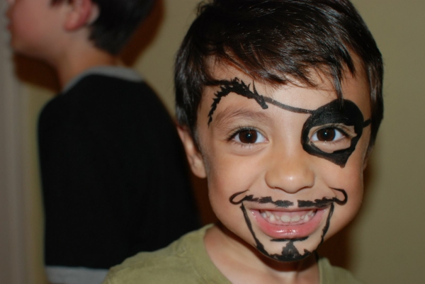 Mali nasmiješeni dječak s piratskim šminkom