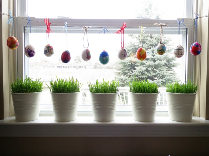 Huevos de Pascua y hierba de Pascua como decoración de ventana