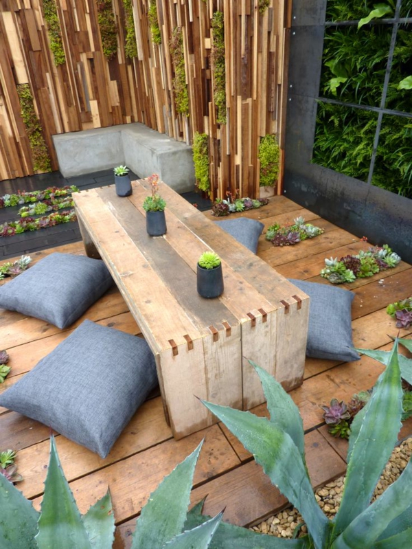 طاولة خشبية والوسائد في حديقة