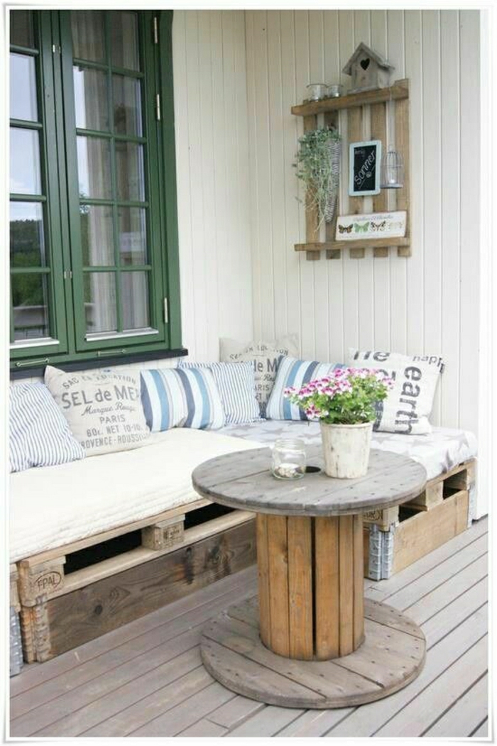 Veranda terasz kerti bútorokkal raklap kanapé dohányzóasztal párna virágcserép