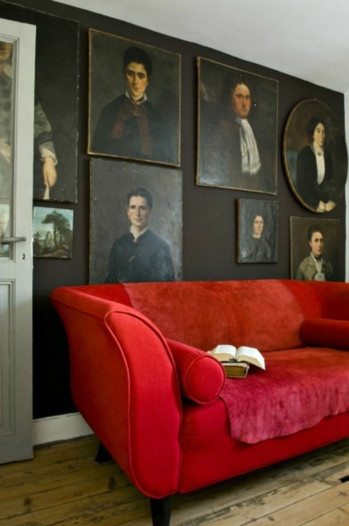Habitación con muchos-retratos-an-der-pared del sofá rojo