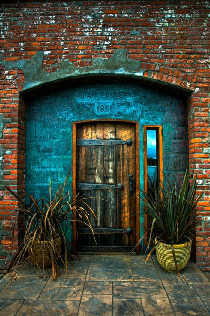 الأبواب الأمامية الخشب والحلي المعدنية القديمة مبنى من الطوب أواني الزهور