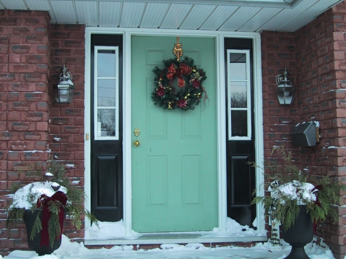 régi bejárati ajtók-zöld-tégla ház virágcserepek lámpa karácsonyi dekoráció koszorú