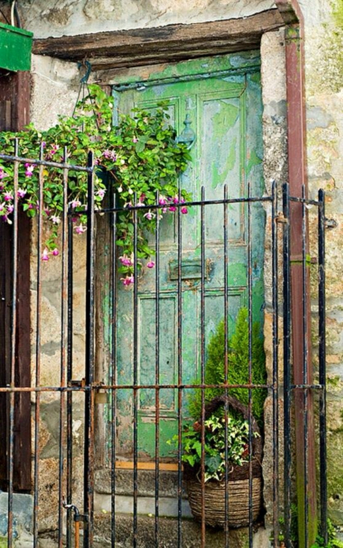 viejo-verde-puerta maceta de flores que cuelga cerca