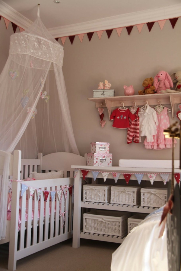 Colgador de ropa con cortinas transparentes en la habitación del bebé