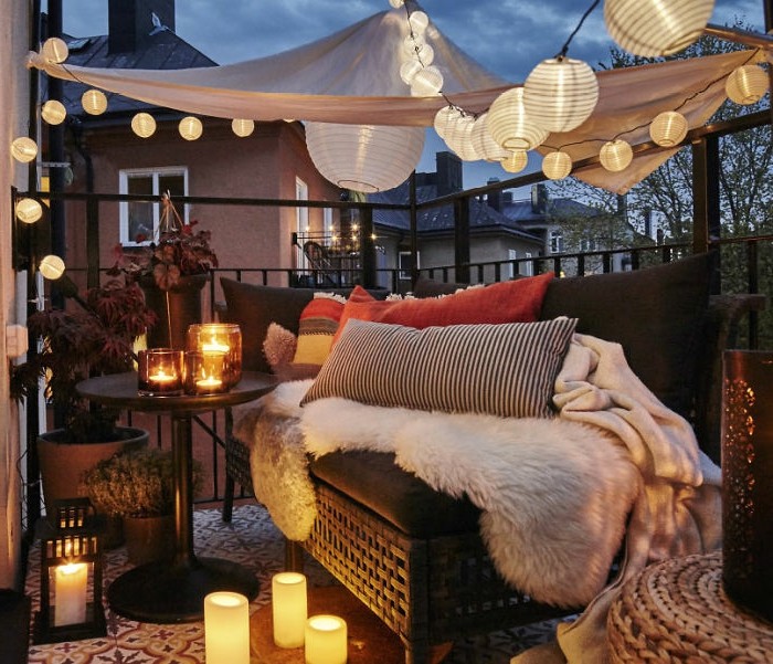 balkon-ideje-flechtcouch spavanje deka-uzorak jastuk-uzorak tepiha-okrugli stol-svijeće-neizravnu-svjetlo