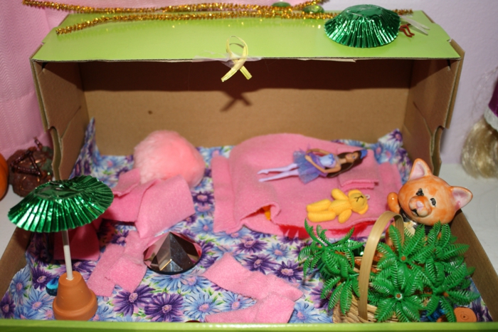 A cipő dobozban házat készítenek a rózsaszínű játékok és babák számára