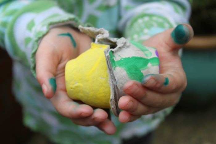 Мръсни ръце на дете, носещи две кутии за яйца - Великденски занаяти с картонена кутия за яйца