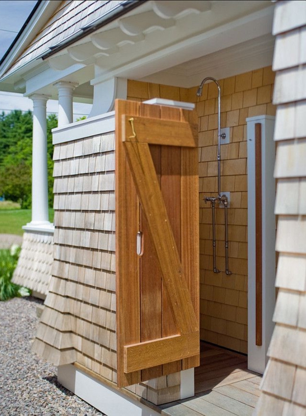 Drvena tuš kabina ispred kuće s drvenim vratima