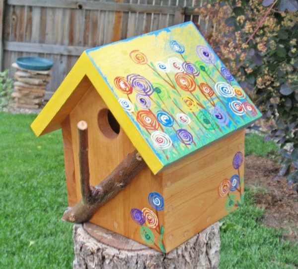 Slikano hranjenje kuća-od-drva ptica u vrtu