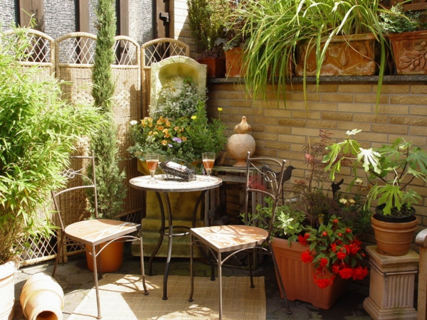 Тераса с зелени растения, кръгла маса и два стола