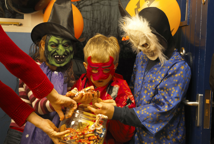Halloween slike - neka djeca s zastrašujućim maskama okupljaju slatkiše