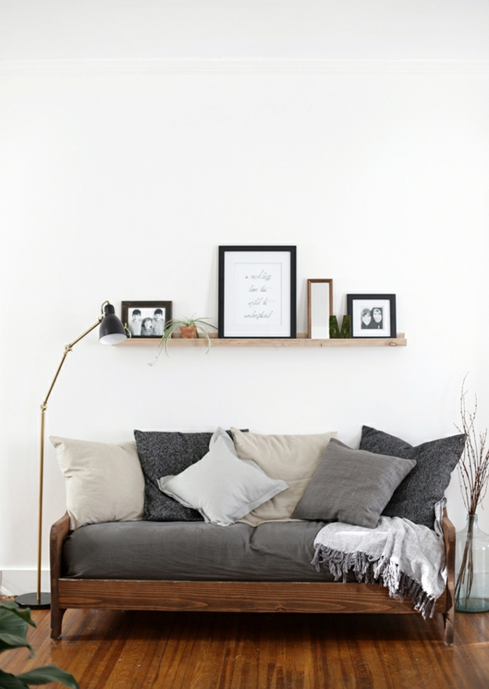 Sofa u sivoj boji, jednobojni jastuci - slikovnica s malom posudicom za cvijeće