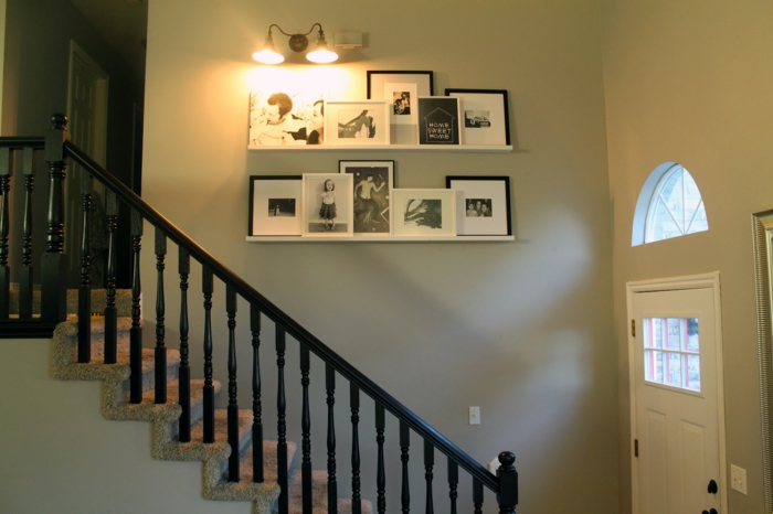 رف الصور في المدخل جدران بيضاء درج اثنين من المصابيح