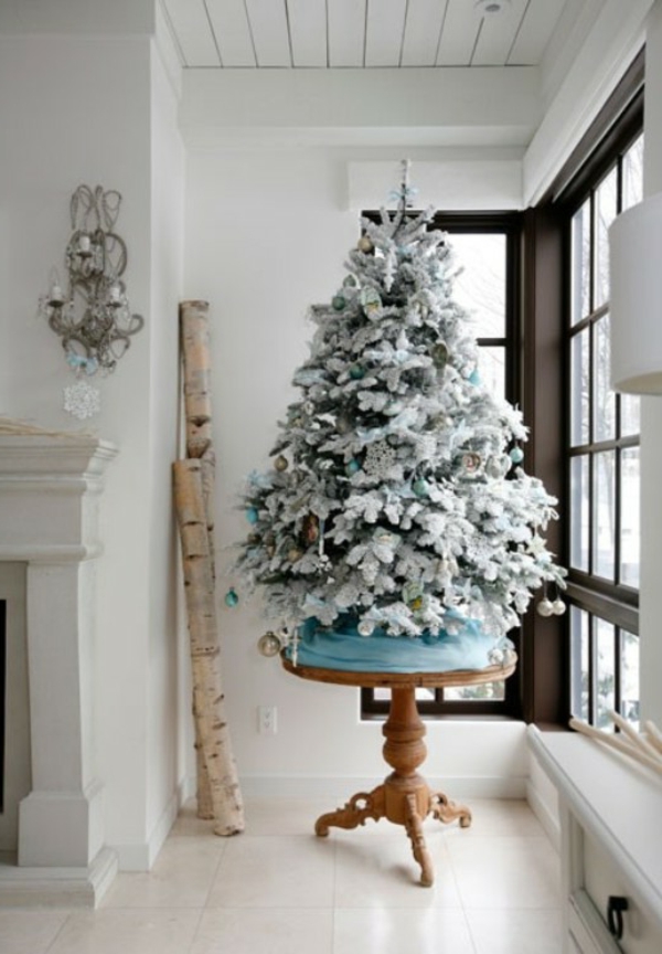fehér karácsonyi díszítés - üvegfal és egy karácsonyfa mellett