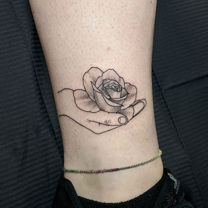 egy rózsa a kezében, egyszerű tetoválás a láb tetoválás reális ékszerek