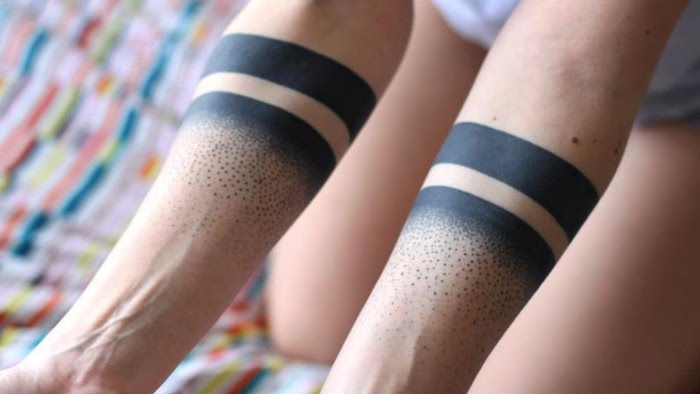 две гривни в черно Цветна черна татуировка с малки петна от двете ръце