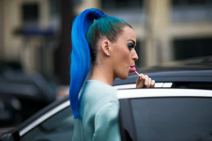 Katy Perry con cola de caballo azul, colorete de durazno, sombra de ojos azul, foto de paparazzi, piruleta