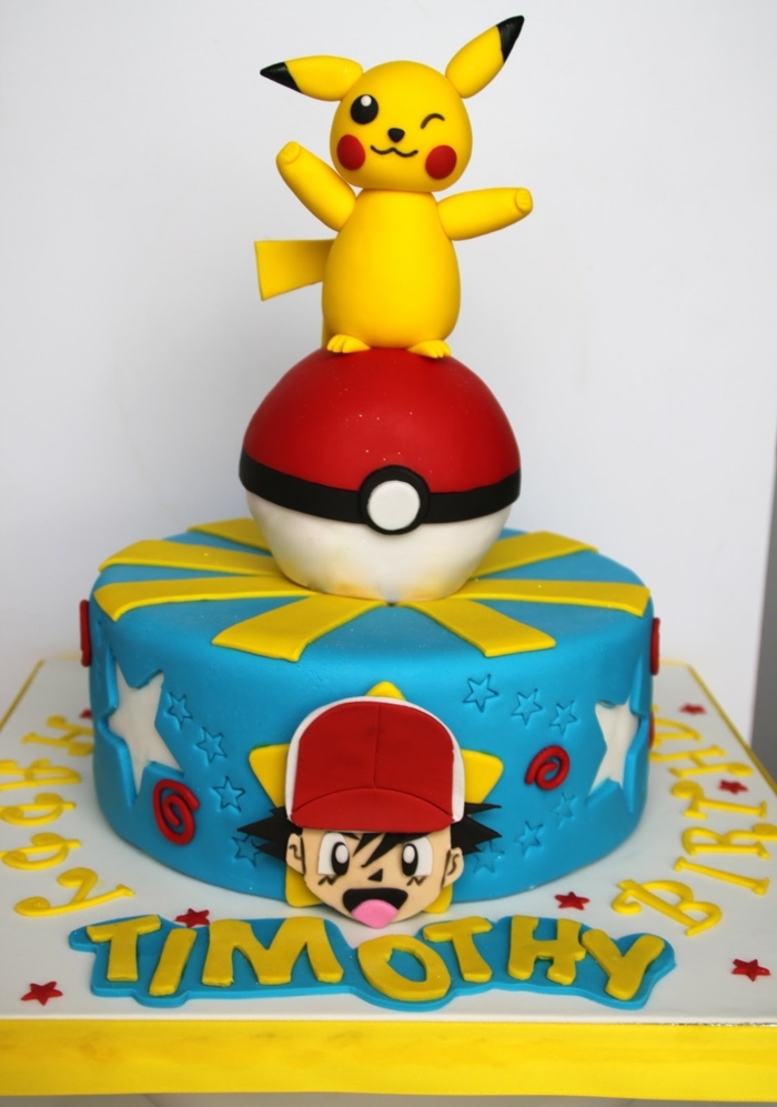 idée d'une tarte au pokemon bleu - un petit pokémon étant pikachu avec des yeux noirs et des joues rouges et un pokeball rouge et un garçon avec une casquette
