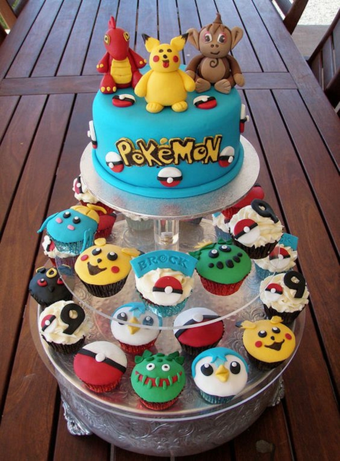petit gâteau pokemon avec une essence différente de pokemon et une tarte pokemon bleue avec un pikachu jaune, un pokemon de dragon et des titres jaunes