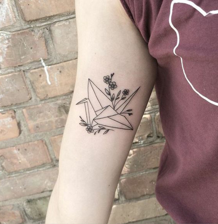 Ето една ръка с малко черно оригами татуировка - летящ оригами гълъб и малки цветя