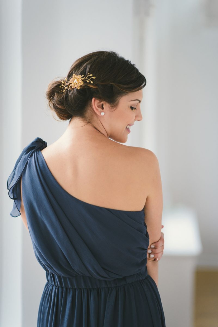 Bridesmaids kampailee sinistä mekkoa paljain olkapään hiustarvikkeet kuten kultainen kukka