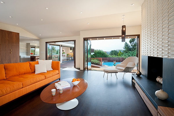 غرفة معيشة مع أريكة برتقالية وخارجية - حمام سباحة