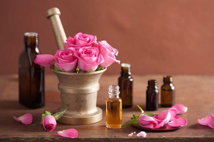 Направете сами козметика: розово масло в козметични бутилки от тъмно стъкло, розови листенца, рози, хоросан