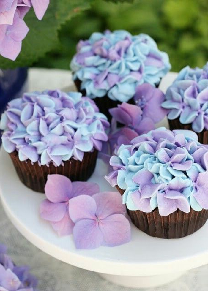 Muffins con flores de crema en azul y púrpura decorar