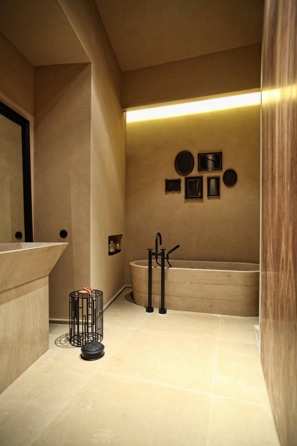 الحمام مع حوض الاستحمام في لون الأوكرا والضوء المضاء بالجدار