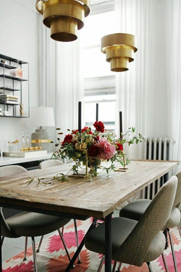 Koristeelliset kukat, puinen pöytä ja kullanvärinen kattokruunu ruokasalissa