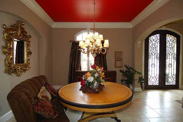 एक लाल छत के साथ रहने वाले कमरे में गोल लकड़ी की मेज