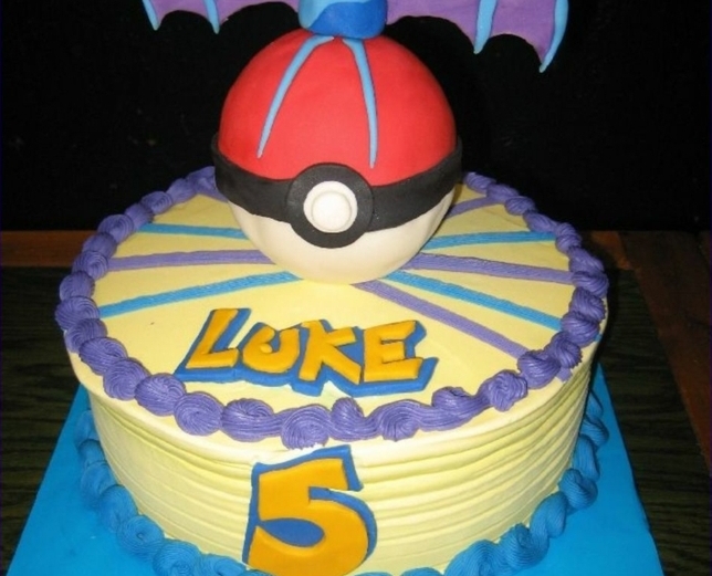 Excellente idée pour un gâteau pokemon avec une crème pourpre, une pokeball rouge et des titres jaunes