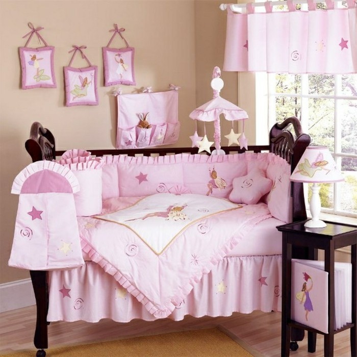 cama de bebé interesante con ropa de cama rosada - gran diseño