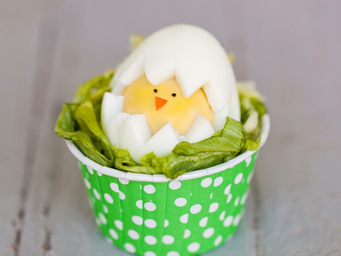 vicces húsvéti tojások csirke a saláta, zöld csésze pontokkal