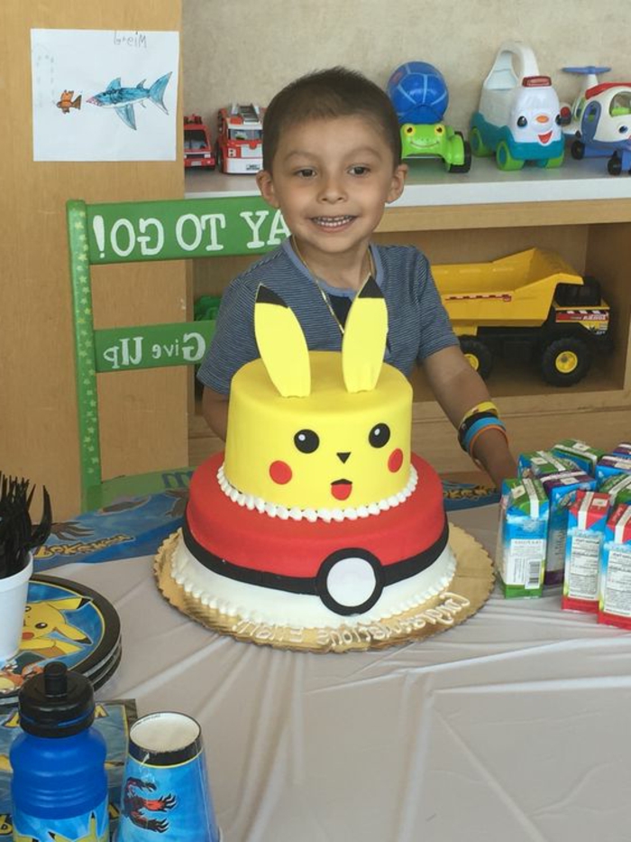 voici kid avec une tarte de deux étages - un pokemon jaune étant pikachu et un pokeball rouge