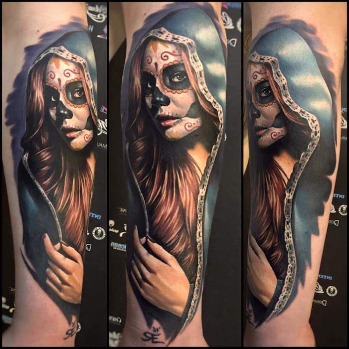 Main avec un gros tatouage La Catrina avec une jeune femme décédée aux yeux noirs et un nez noir et un vernis à ongles rouge