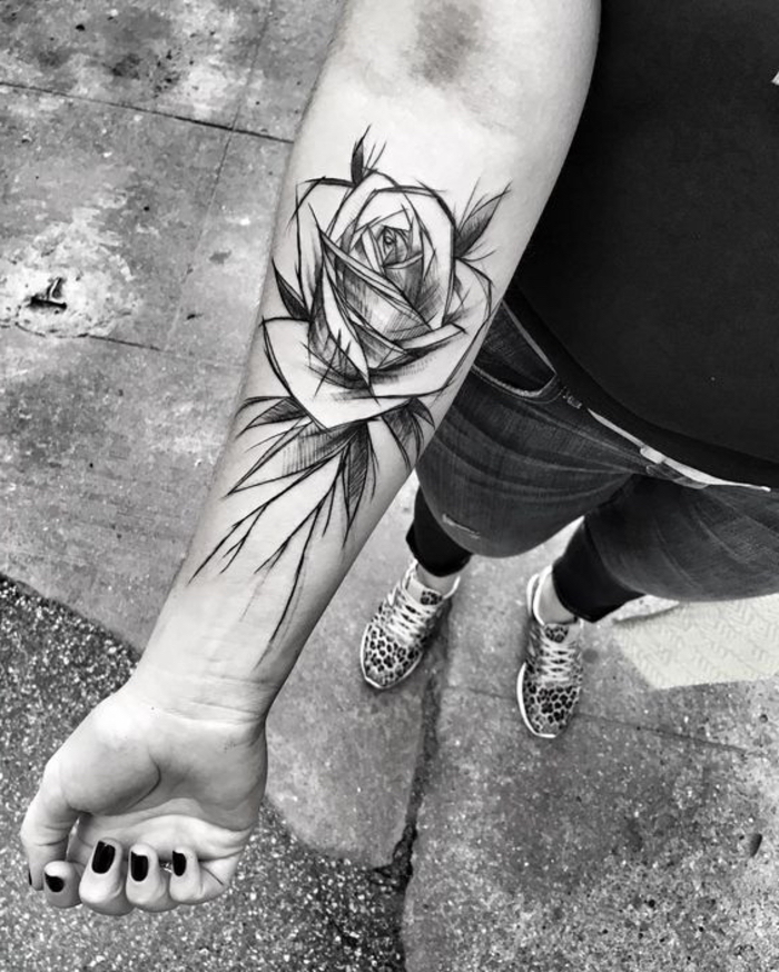 una chica con un gran tatuaje negro. plantilla de tatuaje rosas - mano con esmalte de uñas negro