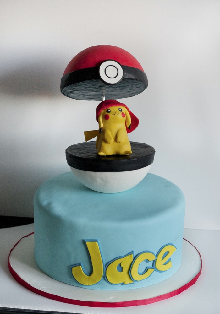un pokeball rouge avec une petite créature jaune pokemon pikachu avec une casquette rouge - idée d'un joli gâteau pokemon