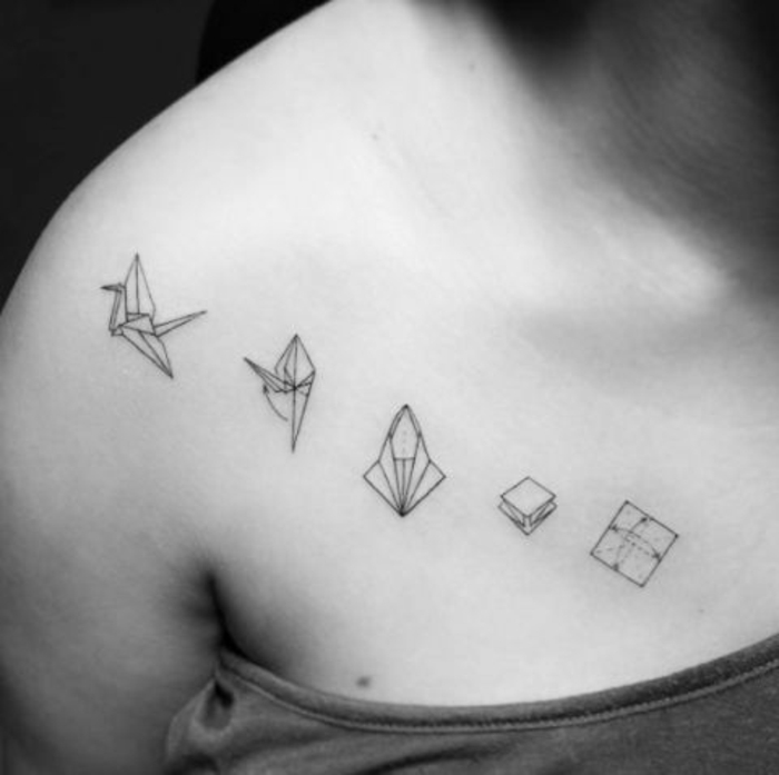 Tässä on origami-tatuointi, jossa on rigami-käsikirja ja pieni lentävä valkoinen lintu - idea tatuoinnille