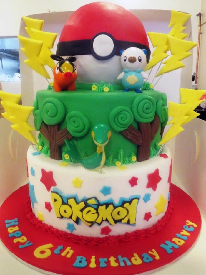 tarte pokemon à deux niveaux avec des arbres verts, un serpent, des éclairs jaunes et un pokeball rouge