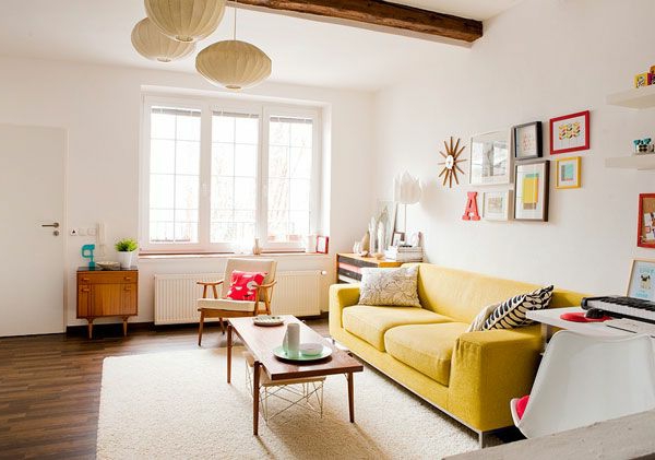 moderni olohuone keltaisella sohvalla, pallomainen kattokruunut ja koriste-esineet